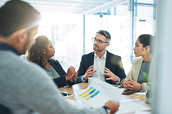 Colleagues discuss a project in a conference room.